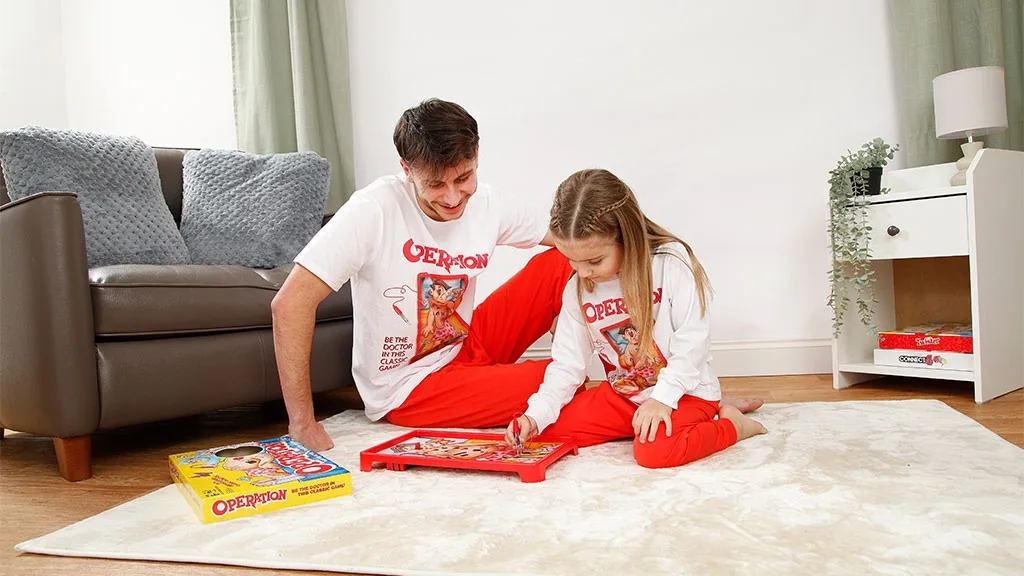 La famiglia può vestirsi con stile per la serata di giochi da tavolo con pigiami a tema giochi da tavolo.